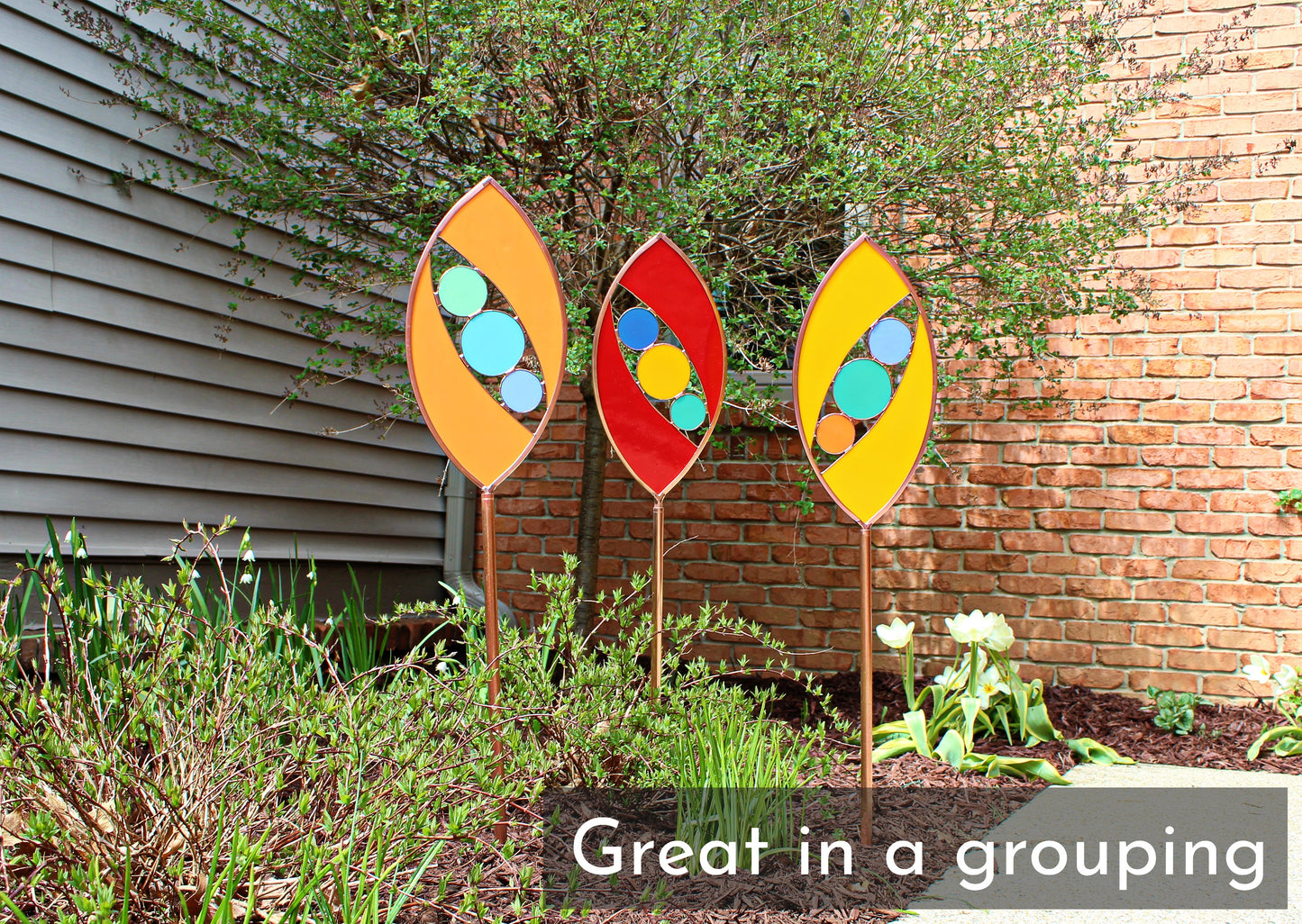 Ellipse shaped glass garden art stake. Persimmon. Copper framed. Opaque glass.
