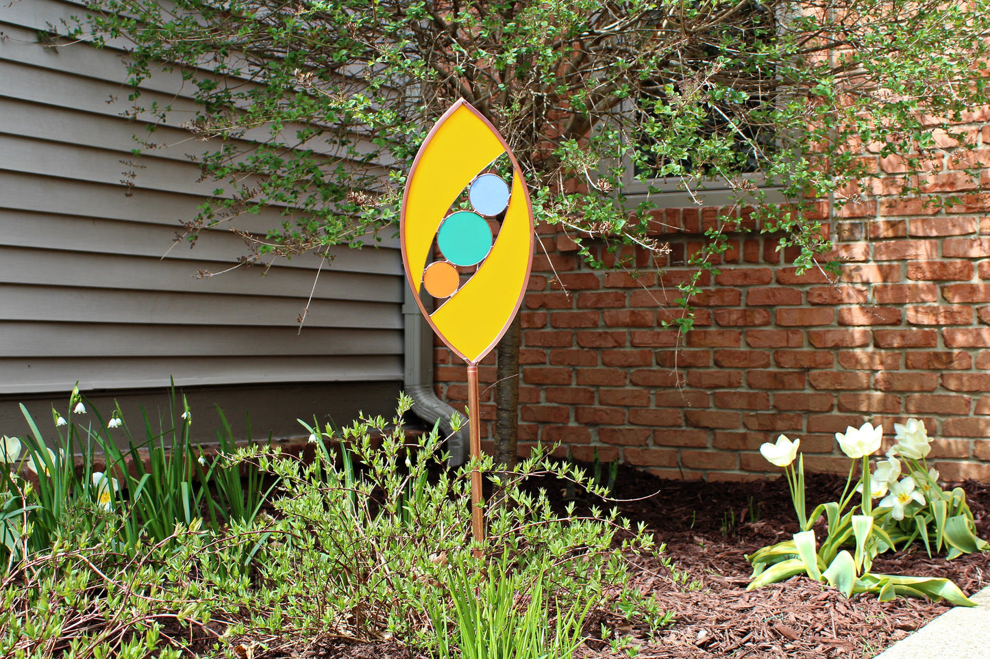 Ellipse shaped glass garden art stake. Marigold. Copper framed. Opaque glass.