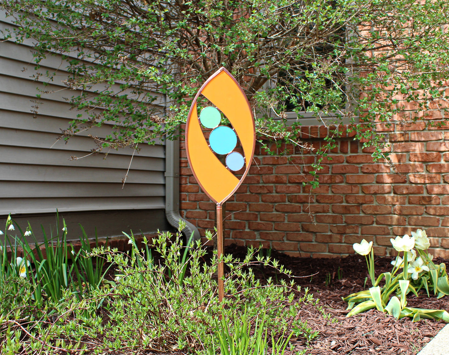 Ellipse shaped glass garden art stake. Persimmon. Copper framed. Opaque glass.