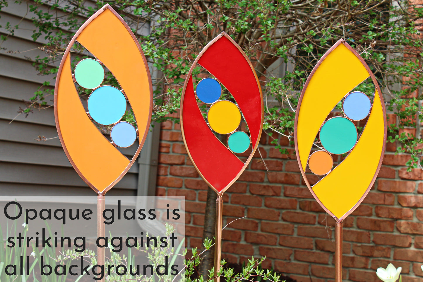 Ellipse shaped glass garden art stake. Persimmon. Copper framed. Opaque glass.