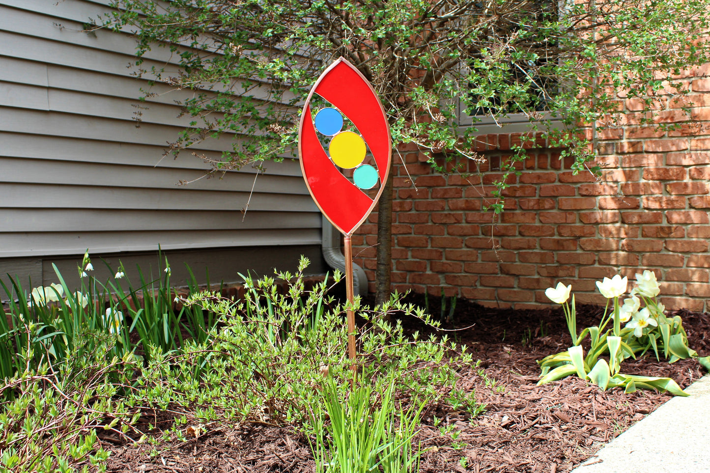 Ellipse shaped glass garden art stake. Red. Copper framed. Opaque glass.